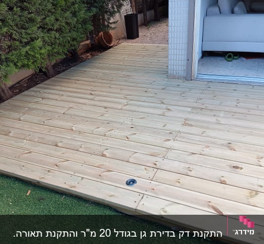 דק עץ חדש ליד דשא סינתטי ועצים ירוקים